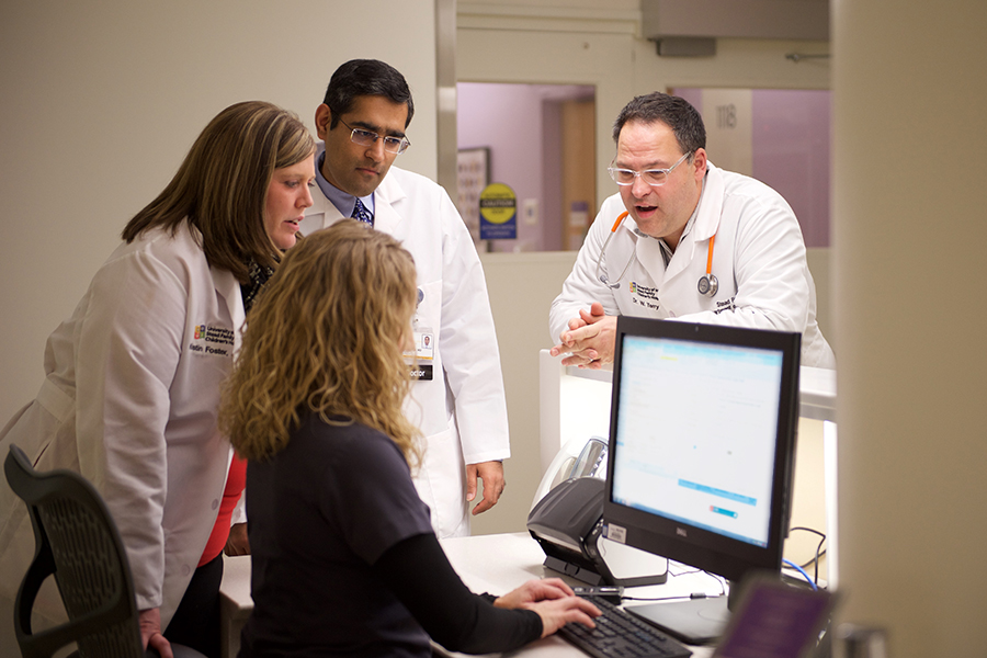 Care team discussing around computer